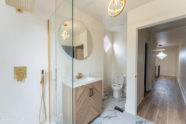 bathroom featuring a wealth of natural light, marble finish floor, vanity, and baseboards