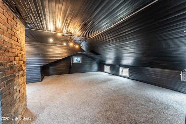 additional living space featuring vaulted ceiling, carpet, and wood ceiling