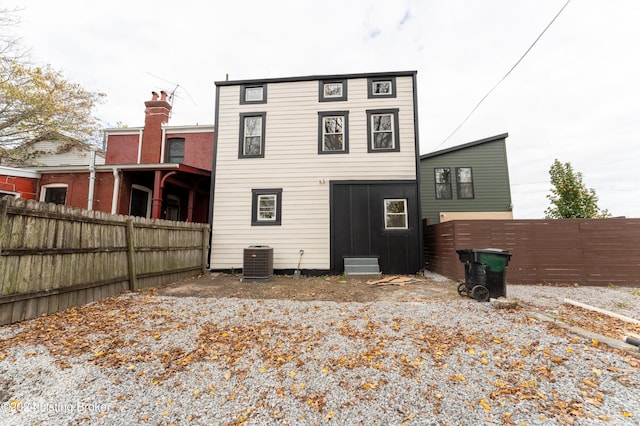 back of house with cooling unit and fence