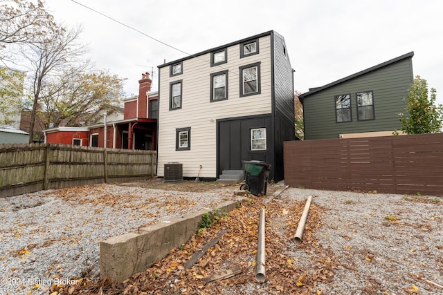 back of property featuring entry steps, cooling unit, fence, and board and batten siding