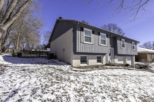 view of front of home with a garage and cooling unit