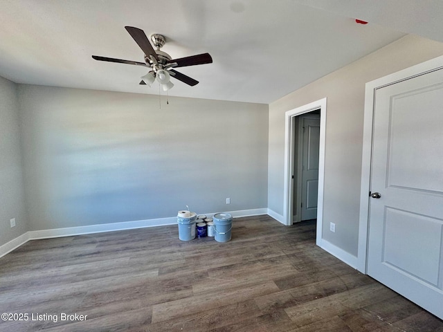 spare room with dark wood-style floors, baseboards, and a ceiling fan