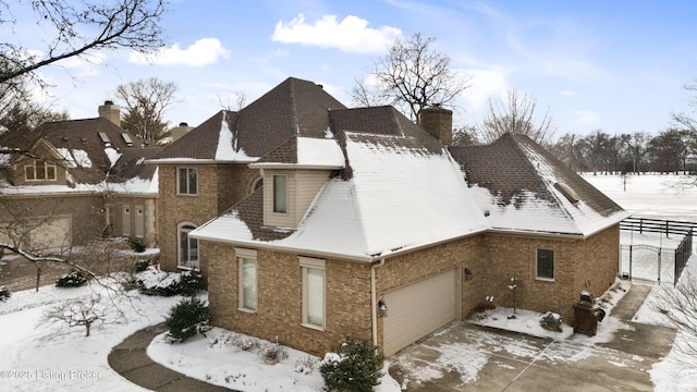 view of snowy exterior featuring a garage