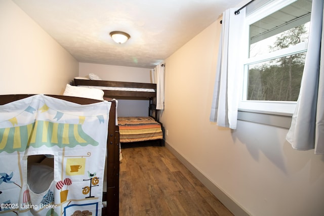 bedroom featuring dark wood-style floors and baseboards