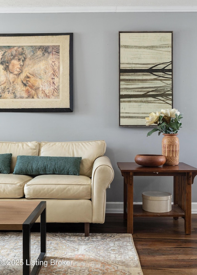 living room with ornamental molding, baseboards, and wood finished floors