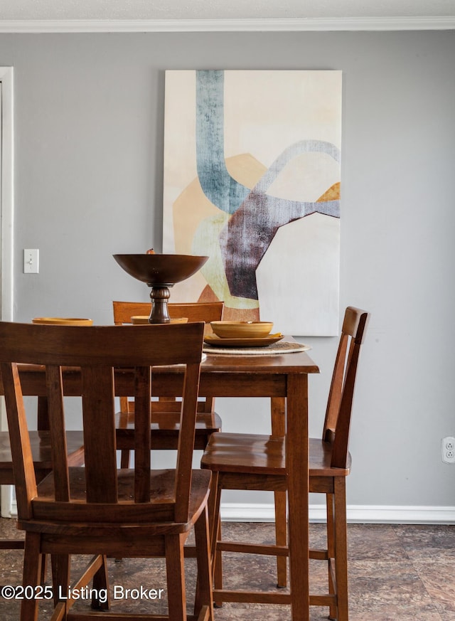 dining room with baseboards and ornamental molding