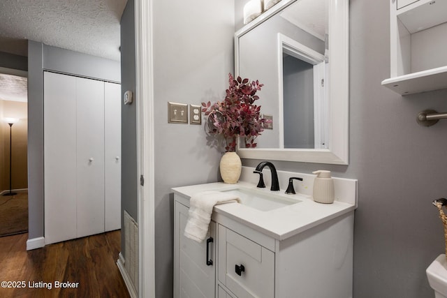 bathroom featuring a textured ceiling, wood finished floors, and vanity