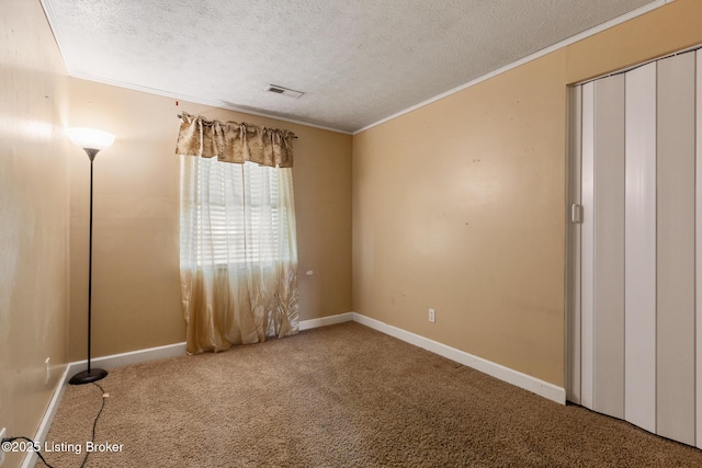 unfurnished bedroom with baseboards, visible vents, ornamental molding, carpet, and a textured ceiling