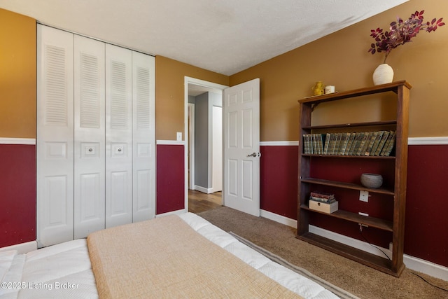 bedroom with carpet floors, baseboards, and a closet