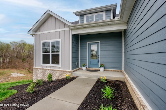 property entrance featuring brick siding and board and batten siding