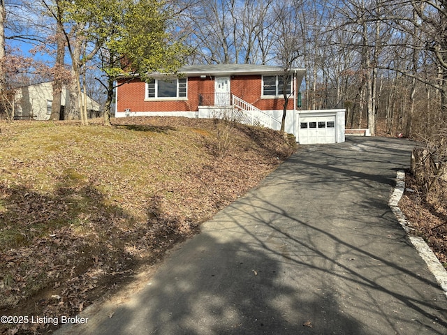 ranch-style house featuring a garage, brick siding, and driveway