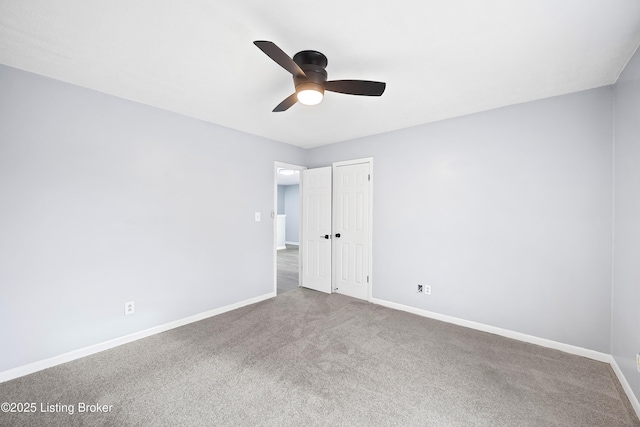 spare room with ceiling fan, carpet flooring, and baseboards