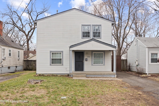 view of front of property with aphalt driveway, fence, and a front lawn