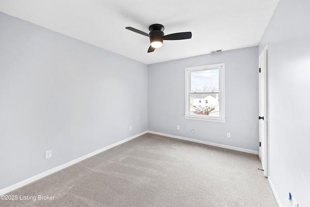 empty room with light colored carpet, visible vents, ceiling fan, and baseboards