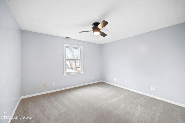 carpeted spare room featuring visible vents, ceiling fan, and baseboards