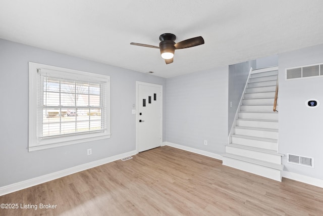 entryway with light wood-style flooring, visible vents, stairway, and baseboards