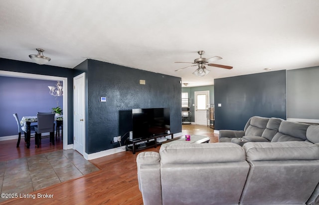 living room featuring a ceiling fan, light wood-style flooring, and baseboards