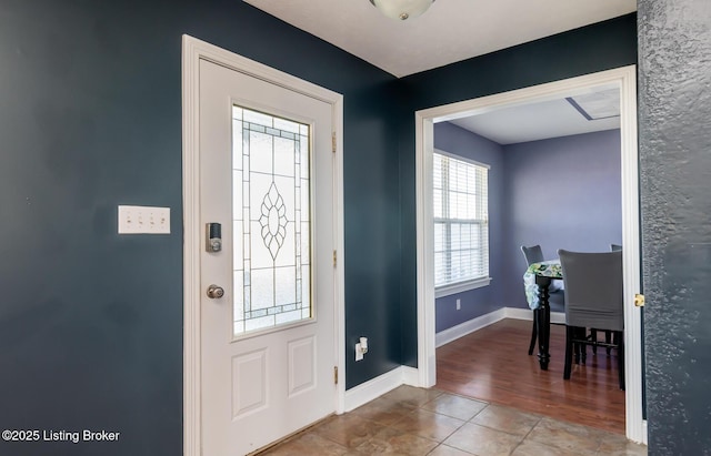 entryway with tile patterned flooring and baseboards