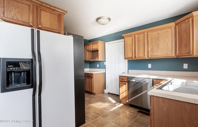 kitchen with tile patterned flooring, white fridge with ice dispenser, light countertops, and stainless steel dishwasher