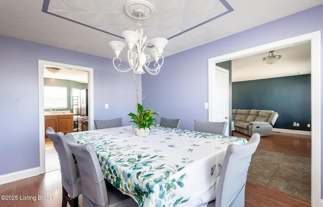 dining room featuring baseboards, dark wood-style flooring, and a notable chandelier