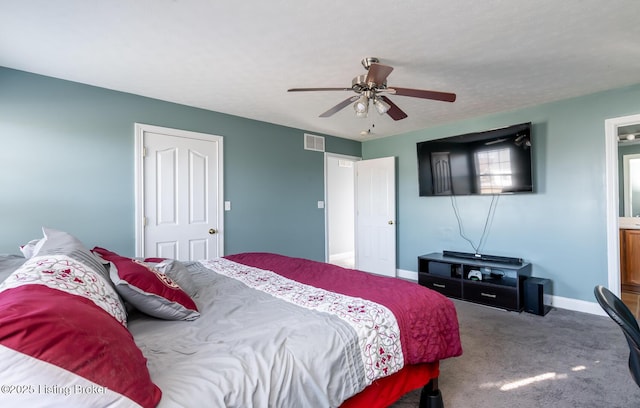 carpeted bedroom featuring baseboards, a textured ceiling, visible vents, and a ceiling fan