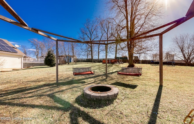 view of yard featuring an outdoor fire pit and fence