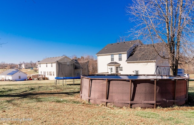 view of yard with a trampoline, a residential view, and an outdoor pool