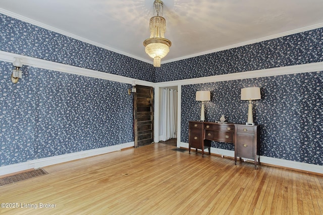 interior space with wallpapered walls, baseboards, visible vents, ornamental molding, and wood finished floors