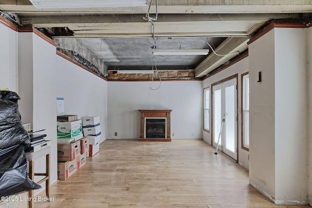 living room with a fireplace with raised hearth and light wood finished floors