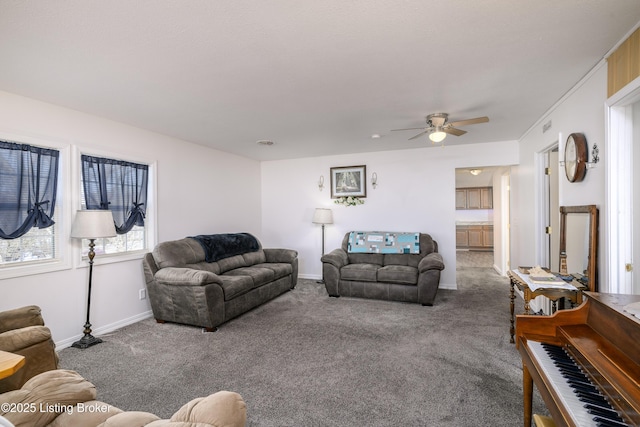 carpeted living room featuring baseboards and a ceiling fan