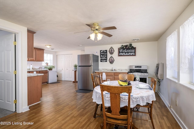 dining room with a wall mounted AC, visible vents, baseboards, a ceiling fan, and dark wood-type flooring