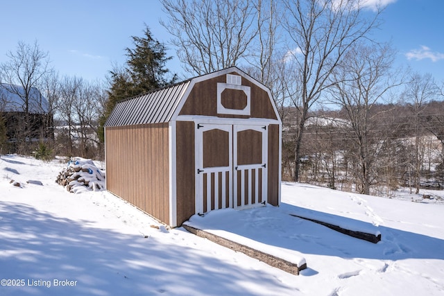 snow covered structure with an outbuilding and a shed