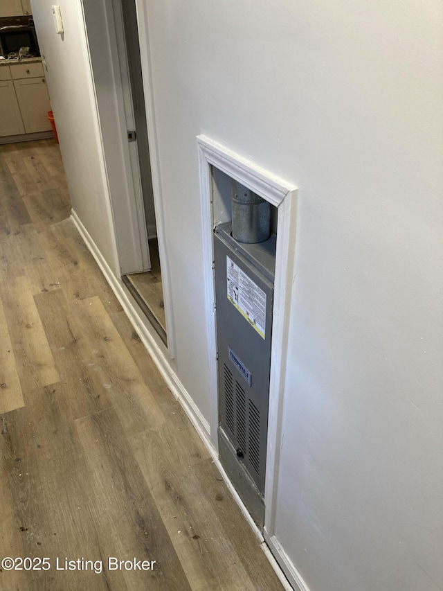 corridor with light wood-style flooring and baseboards