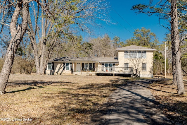 view of front of property featuring a front lawn and a wooden deck