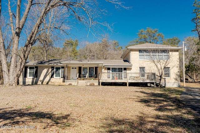 back of property with brick siding and a wooden deck