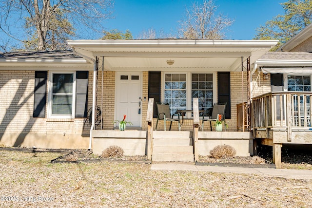 view of front of home featuring covered porch and brick siding