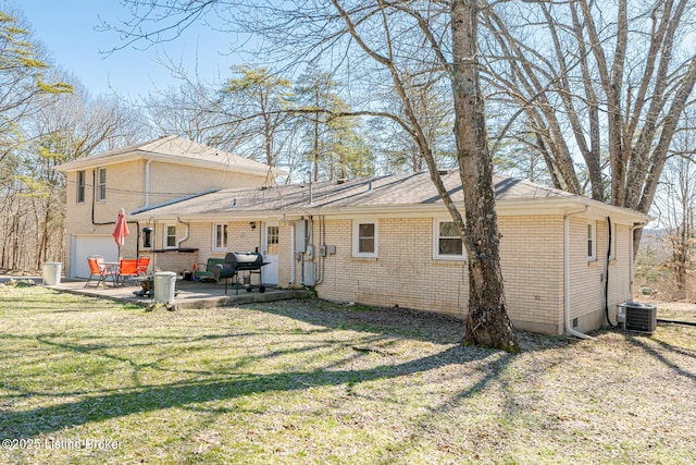 back of house featuring brick siding, a lawn, a patio area, and central air condition unit