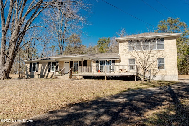 rear view of property with a deck and brick siding