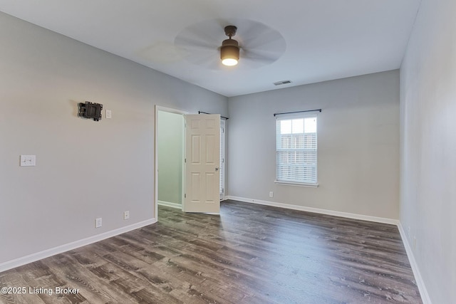 unfurnished room with a ceiling fan, dark wood-style flooring, visible vents, and baseboards