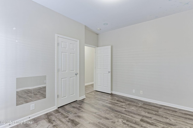 unfurnished bedroom with light wood-type flooring and baseboards