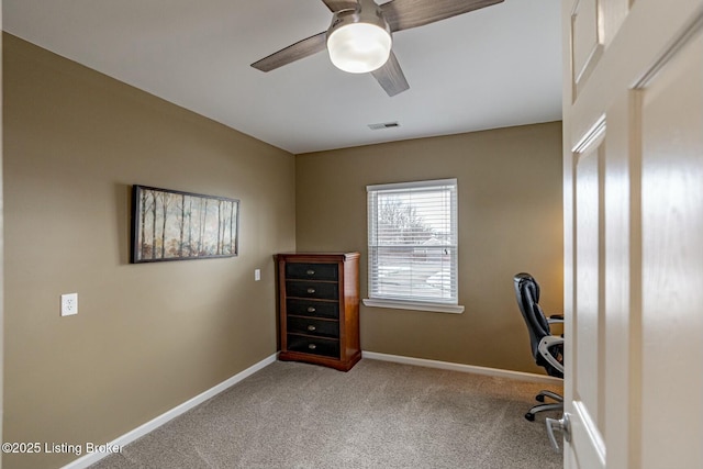 unfurnished office featuring ceiling fan, carpet floors, visible vents, and baseboards