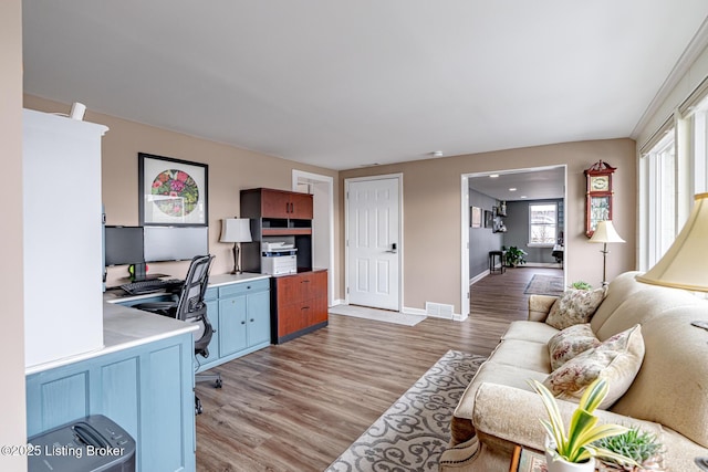 office space featuring visible vents, light wood-style flooring, and baseboards