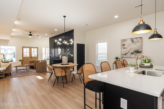 kitchen featuring a sink, light wood-style floors, a healthy amount of sunlight, and light countertops