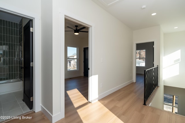 hall featuring recessed lighting, an upstairs landing, baseboards, and light wood finished floors