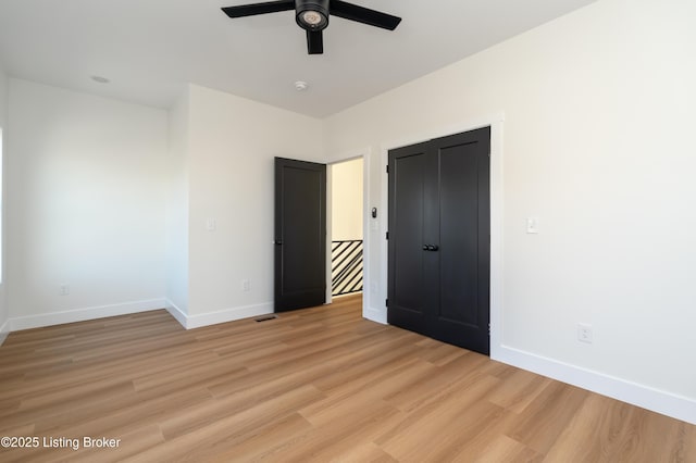 unfurnished bedroom with light wood-style floors, baseboards, and ceiling fan