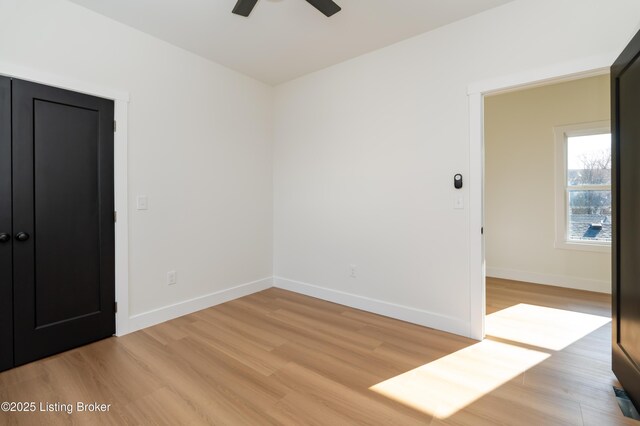 unfurnished bedroom with baseboards, light wood-style flooring, and a ceiling fan