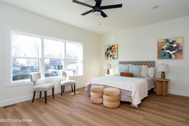 bedroom with baseboards, light wood finished floors, and ceiling fan