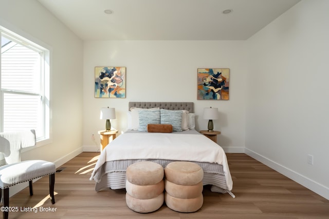 bedroom with wood finished floors and baseboards