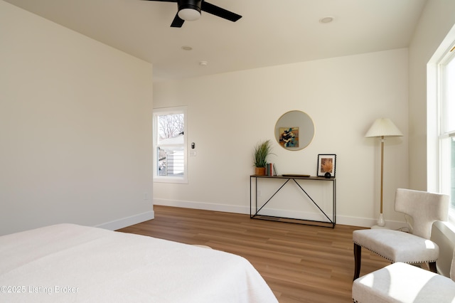 bedroom with baseboards, wood finished floors, and a ceiling fan