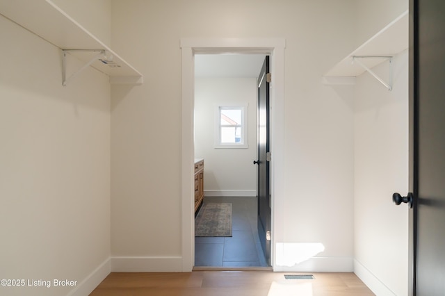 walk in closet featuring wood finished floors